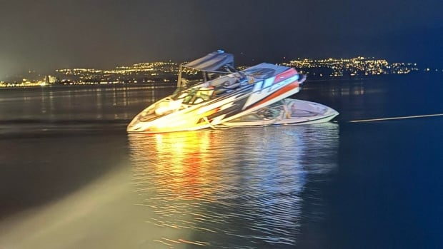 Two boats wedged together on a lake at night.