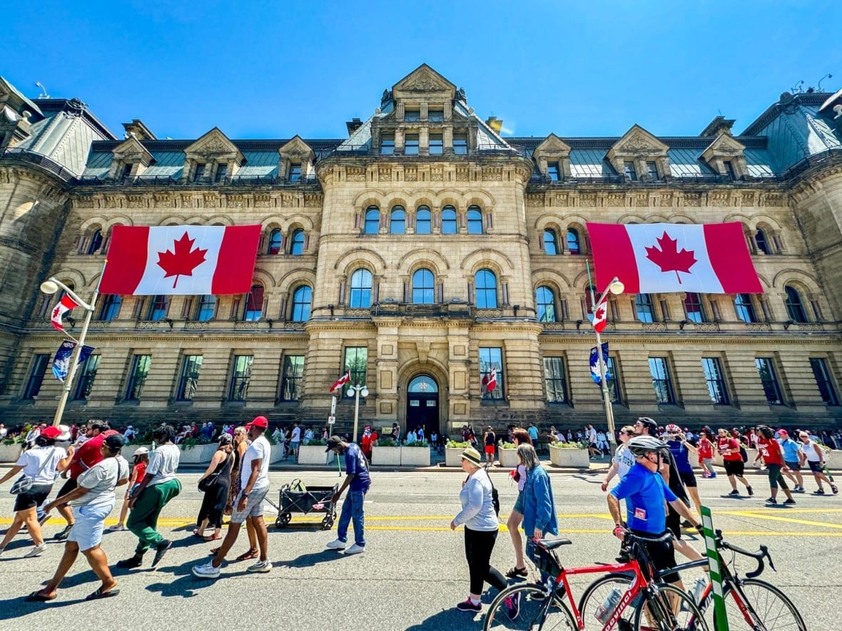 Twin Canadian flags drape the Prime Minister’s Office in Ottawa as crowds celebrate Canada Day.