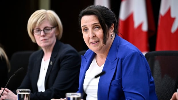 Woman with black hair and blue suit jacket