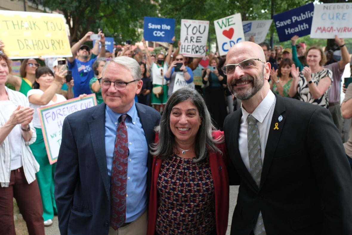 Three senior officials who resigned from the American Centers for Disease Control and Prevention put forward a picture, in front of a crowd of supporters, at the Atlanta headquarters at the Center for Disease Control.