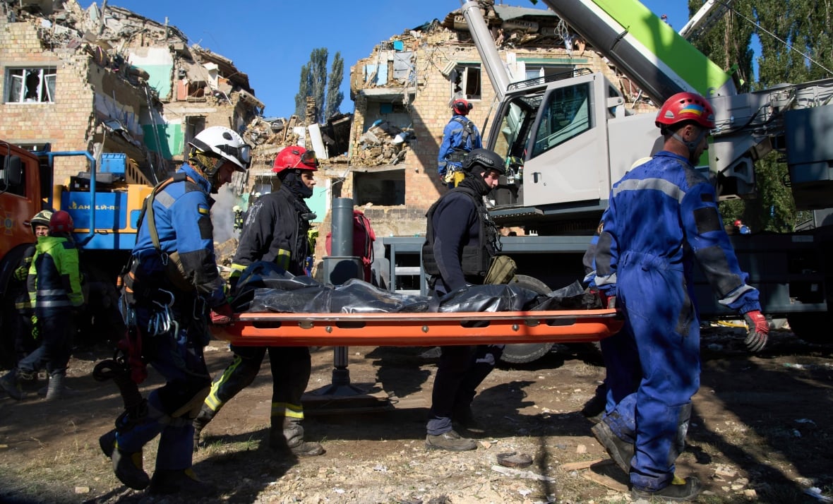 Firefighters who fit the blue carry a savings with a covered personality, with devastating buildings in the background. 