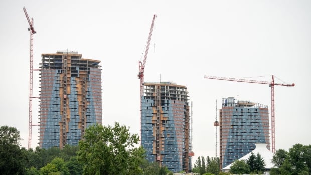 Three apartment towers under construction on an overcast day.