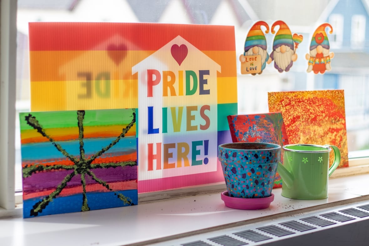 A close-up of a rainbow sign that says "Pride Lives Here."