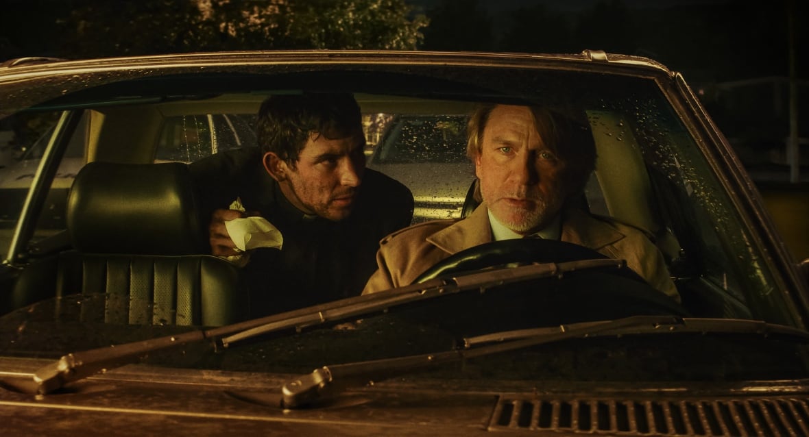 Two men sit in a car.