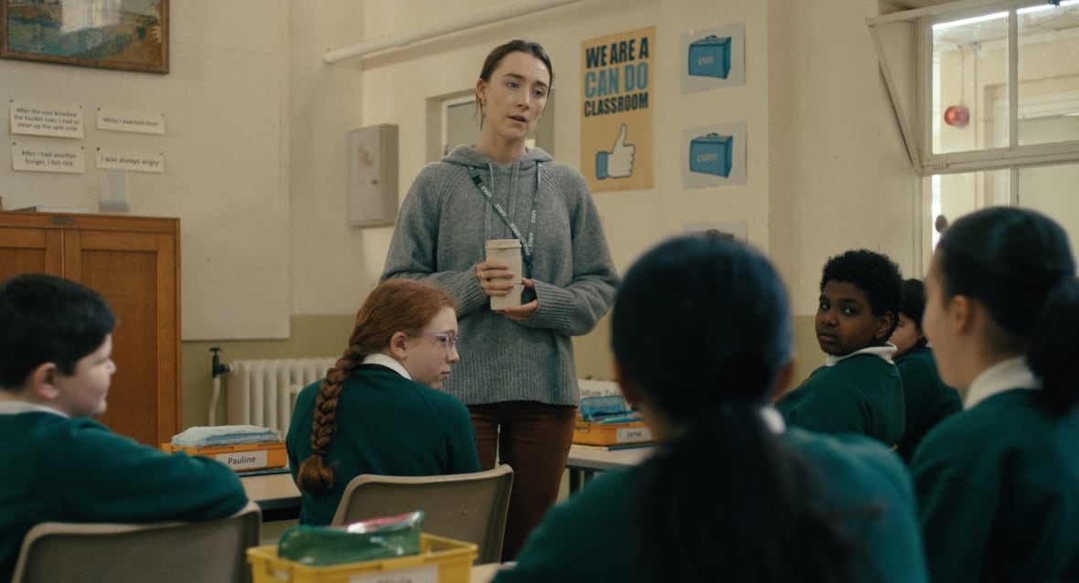 A teacher stands in front of a class of children.