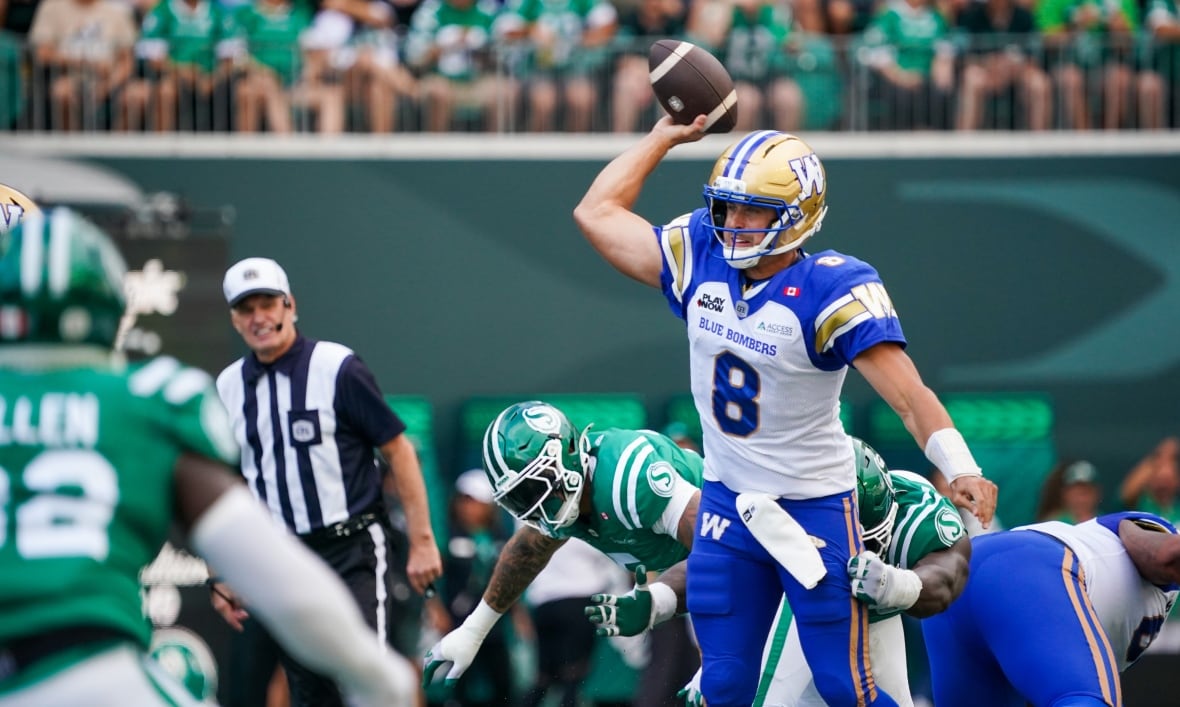 A football player in a #8 blue, gold and white uniform throws a football