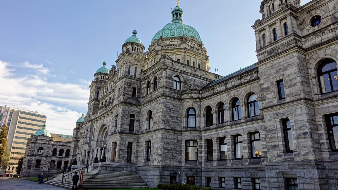 A large Parliament-style building is seen on a sunny day.