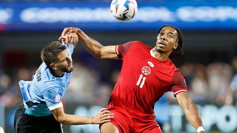 Canadian men’s soccer forward Theo Bair battles for possession of the ball with Uruguay's Rodrigo Bentancur during the Copa America third-place match in Charlotte, North Carolina on July 13, 2024.