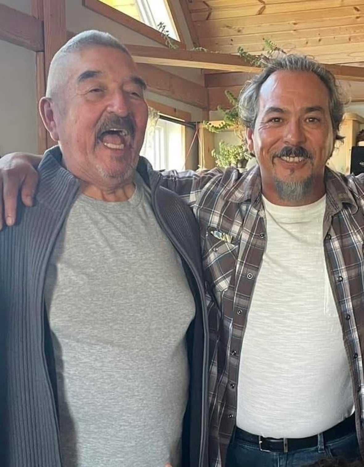 Two men embrace for photo.