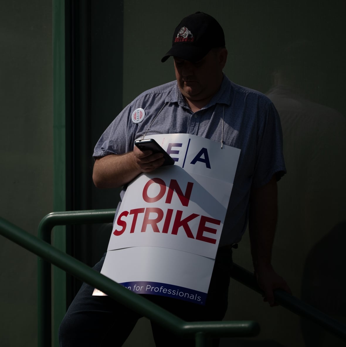 A person wearing a white sandwich board reading 'On Strike'.