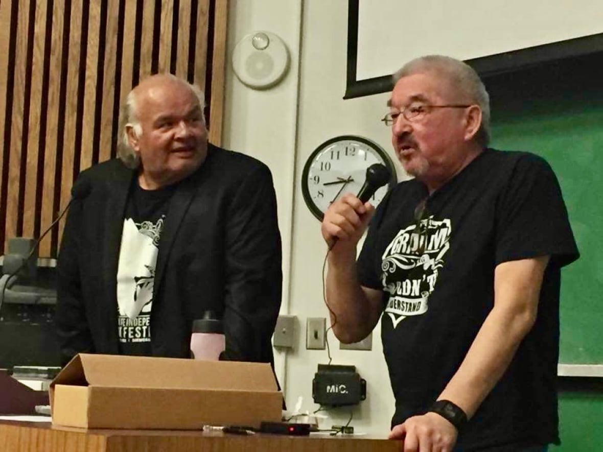 Two men on stage at a mic.