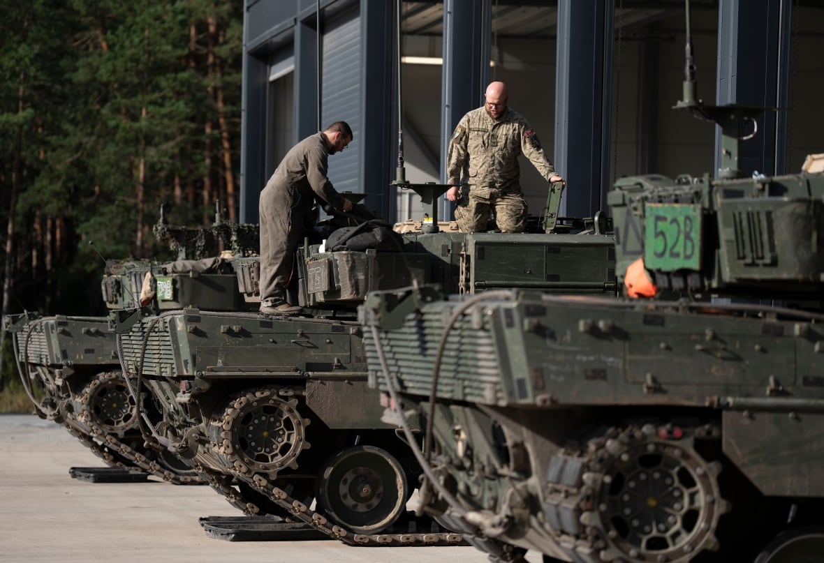 A three-tank line. Two uniform soldiers fall above that.