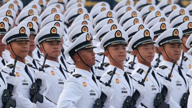 Lines of soldiers in identical white uniforms march together
