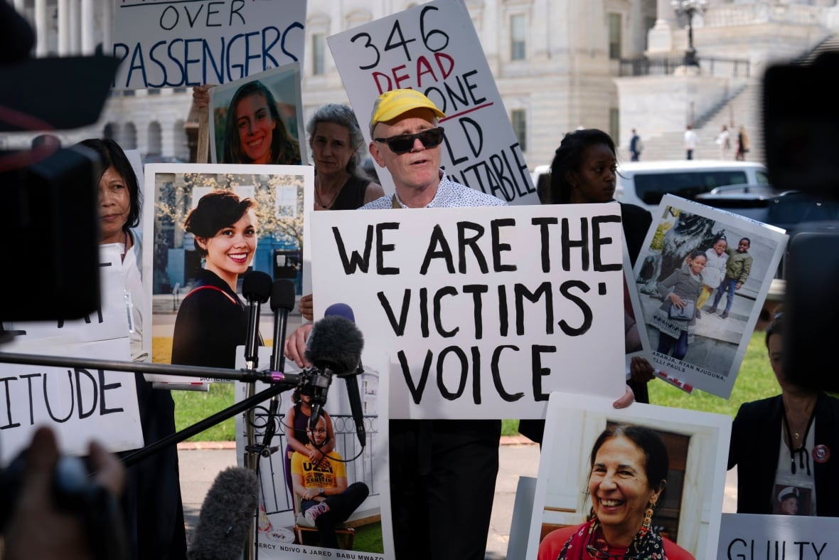 The elderly man appears in a yellow bysoline hat signs in an outdoor demonstration.