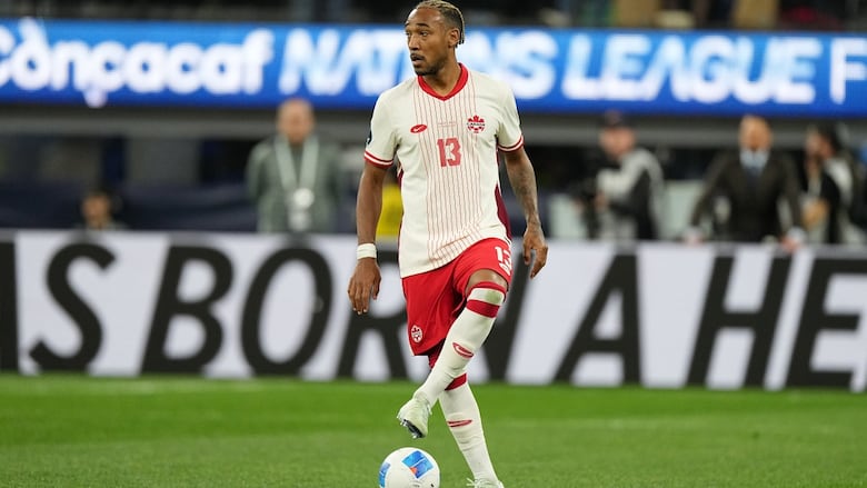 A soccer player runs with the ball.