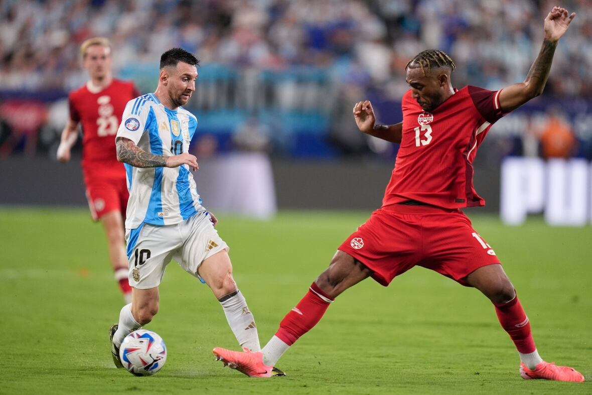 Soccer players battle for the ball.