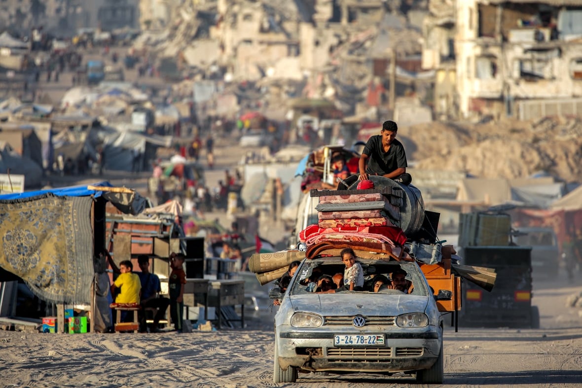 A little girl sitting on a mobile car cover, loaded with property, as she pays a dominant path.