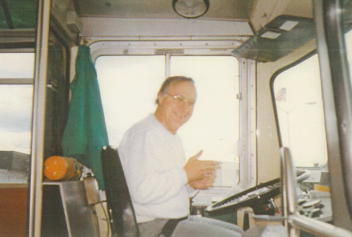 A man behind the wheel of a bus.