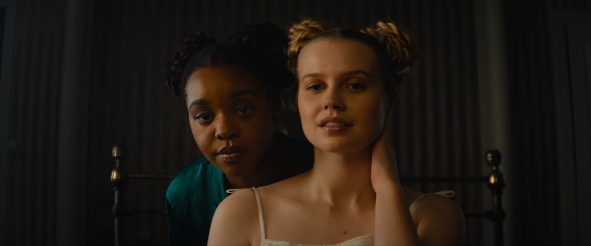 a young Black woman and a young white woman facing forward. 