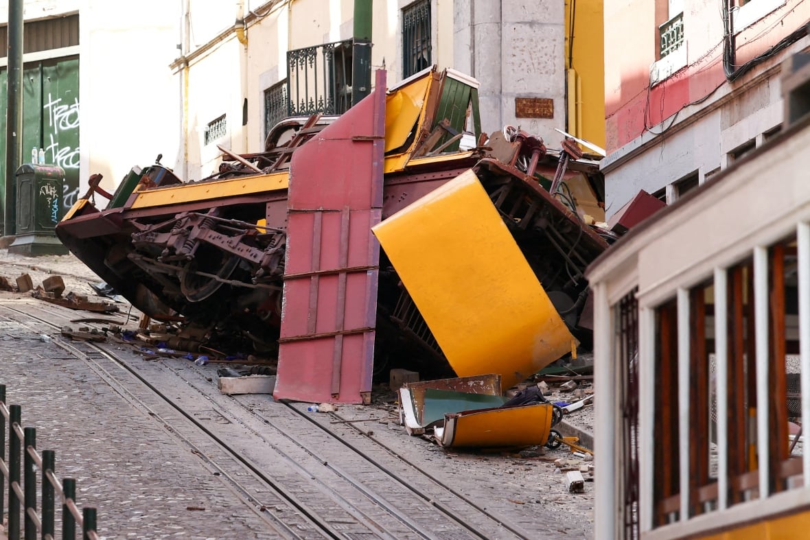 The mineral metal for a yellow train is sitting on the acute narrow street, where it went out of its path.