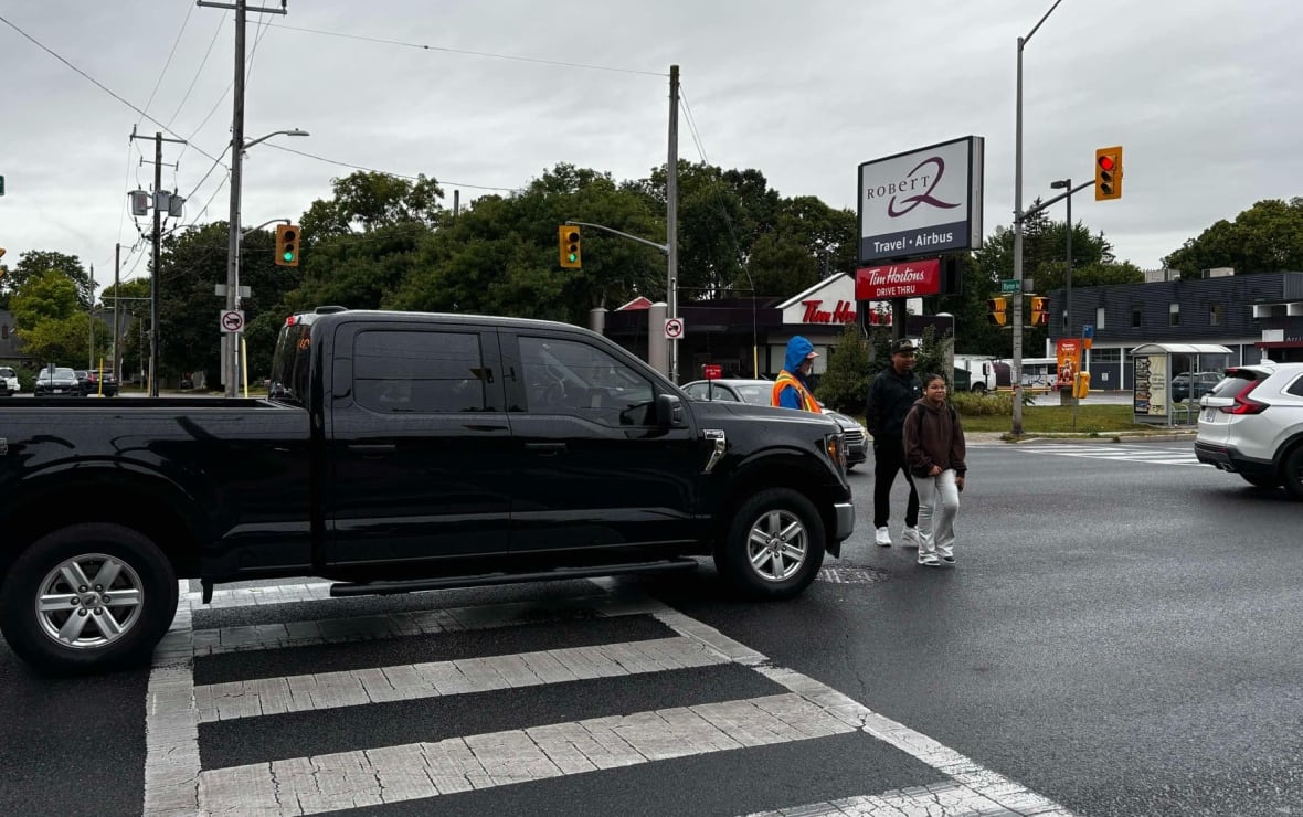 Caminhão na faixa de pedestres, pessoas atravessando a rua