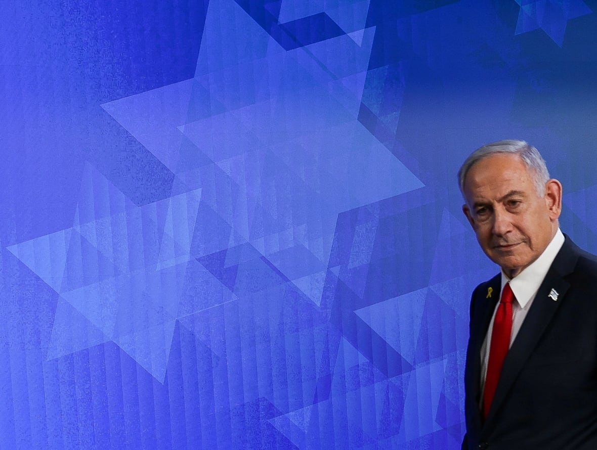 A man stands in front of a blue background