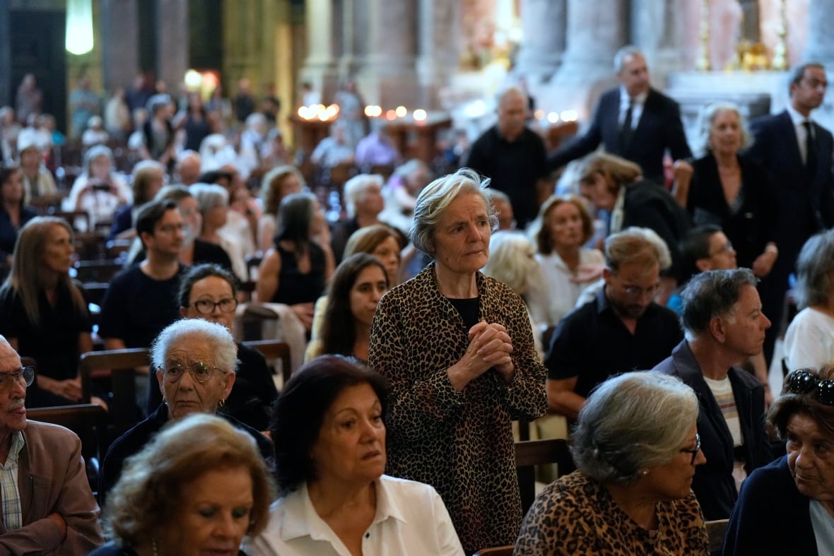 Dozens of people, men and women are displayed inside the church.