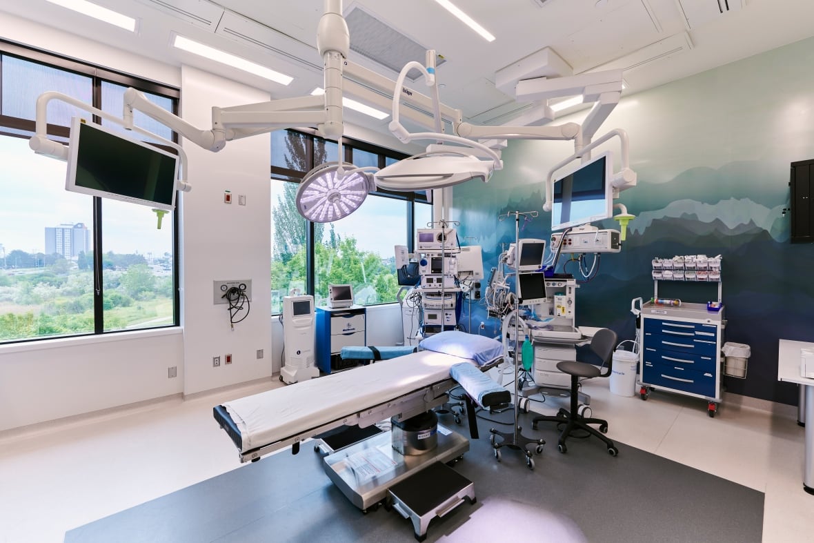 Medical equipment and a table are seen inside a surgical operating room.
