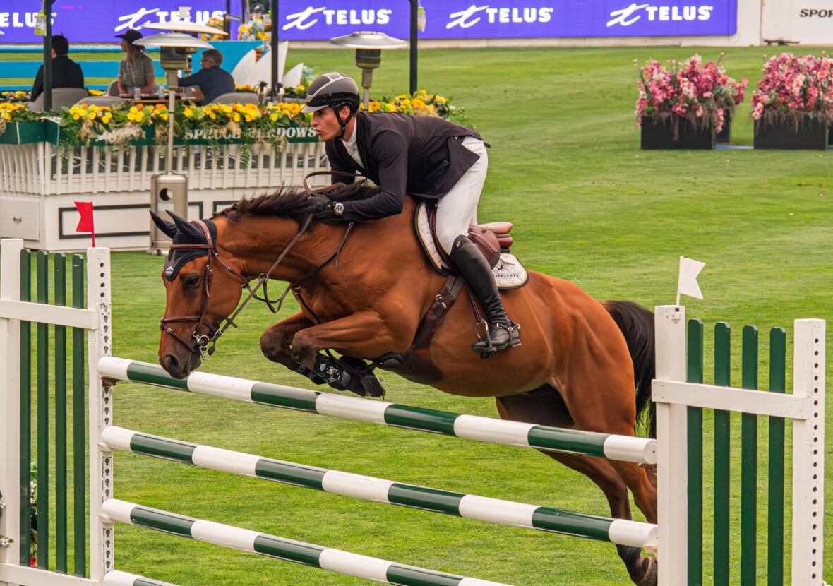 A show jumping team clears an obstacle at Spruce Meadows, a sports and entertainment facility in the southern city limits of Calgary.