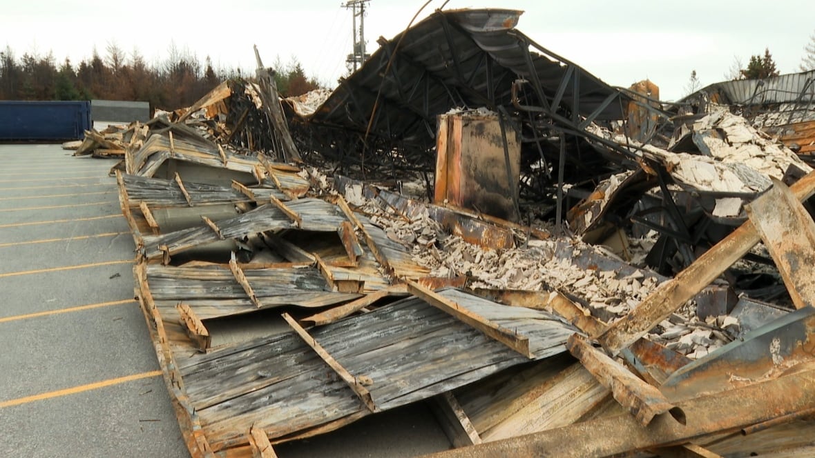 A building has been reduced to rubble and twisted, charred segments of metal.