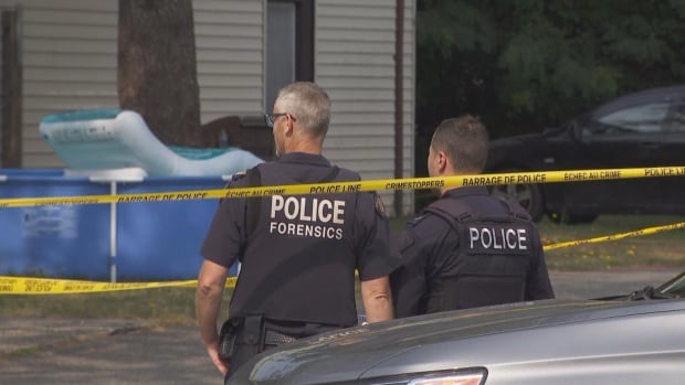 Police stand behind police tape