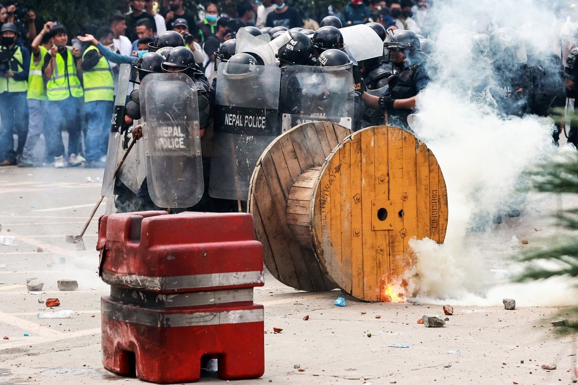 The police broken behind Shields huddled in a street in the city behind a barricade.