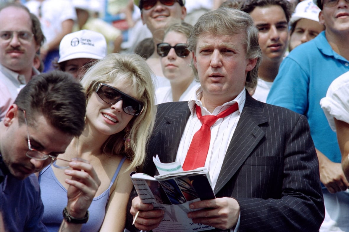 A man in costume sits next to a woman in a crowd