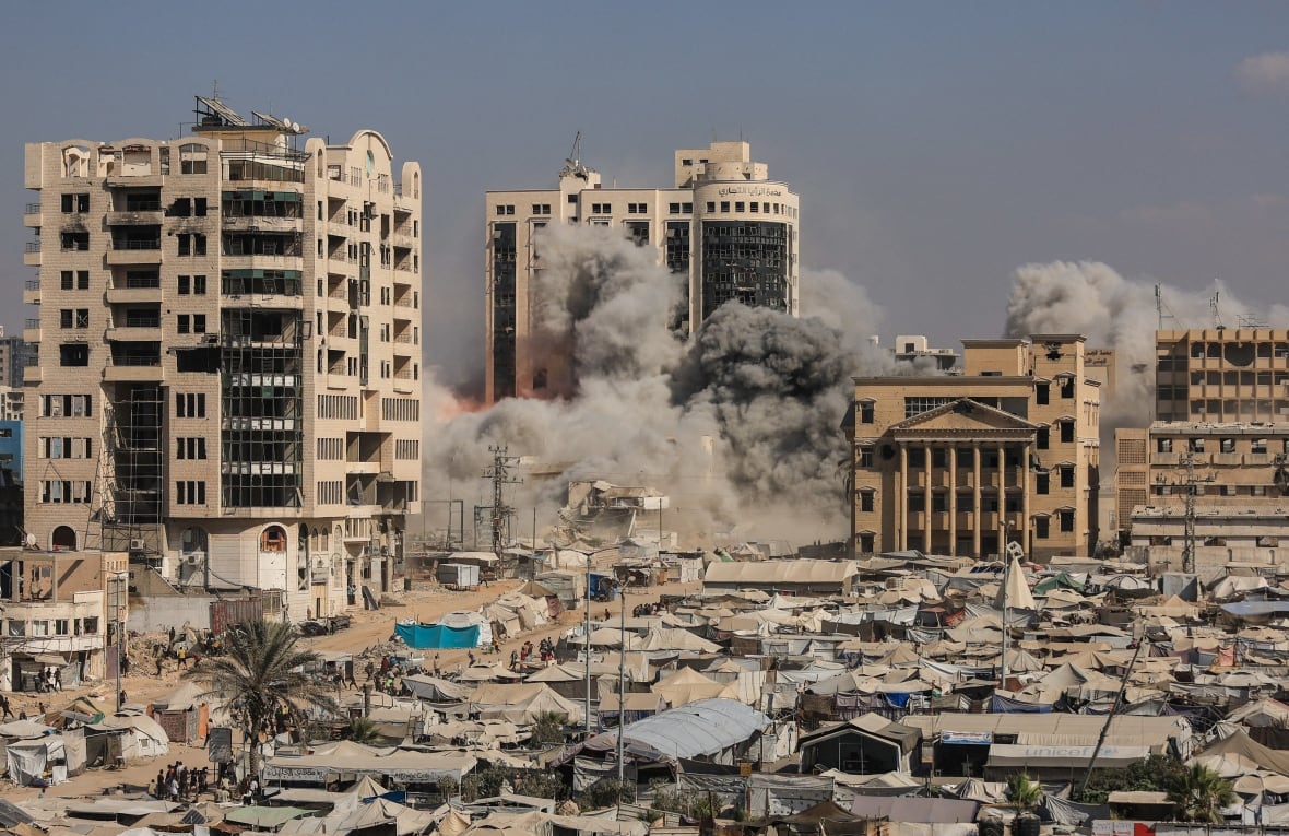 Smoke rises with the collapse of a residential building.