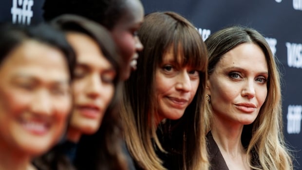 A closeup of four women on a red carpet, with backdrop that reads TIFF.