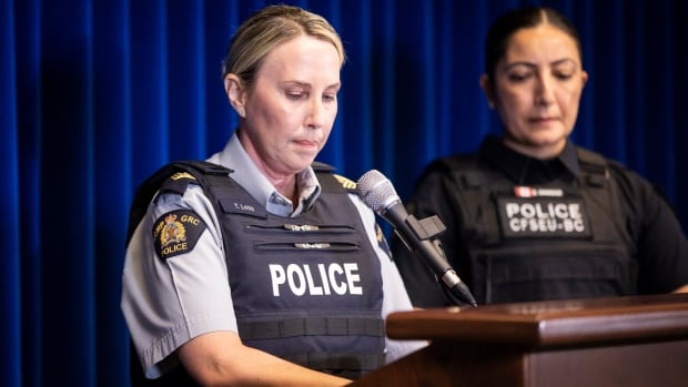 Two police officers are seen at a podium.