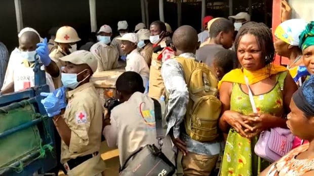 Volunteers load coffins onto a truck