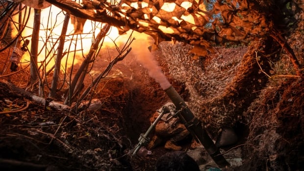 In this photo provided by Ukraine's 93rd Kholodnyi Yar Separate Mechanized Brigade press service, soldiers fire a mortar towards positions of Russian troops near Kostyantynivka in Donetsk region, Ukraine, Tuesday, Aug. 26, 2025. ( via AP) A closeup of a trench in a forested area is shown, with smoke pouring out of a weapon firing ammunition from the bunker.