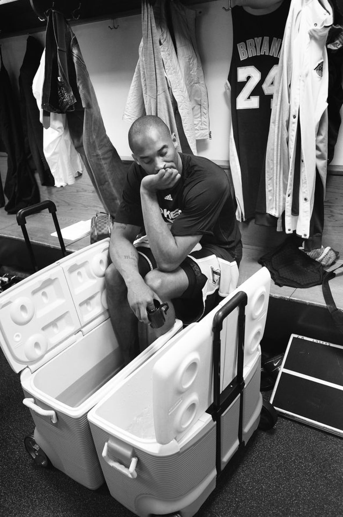 A man sits with his feet in a cooler filled with ice water.