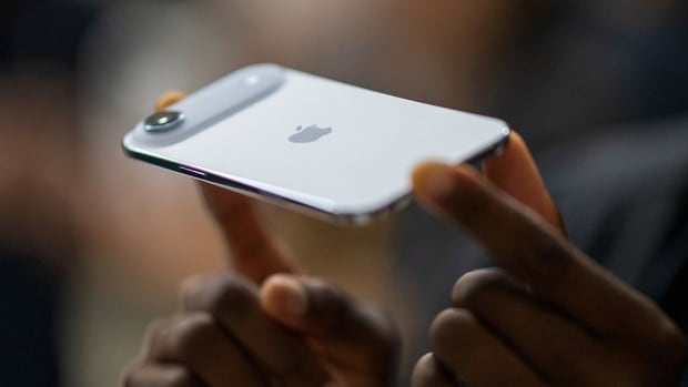 Close up image of hands holding a very thin new iPhone