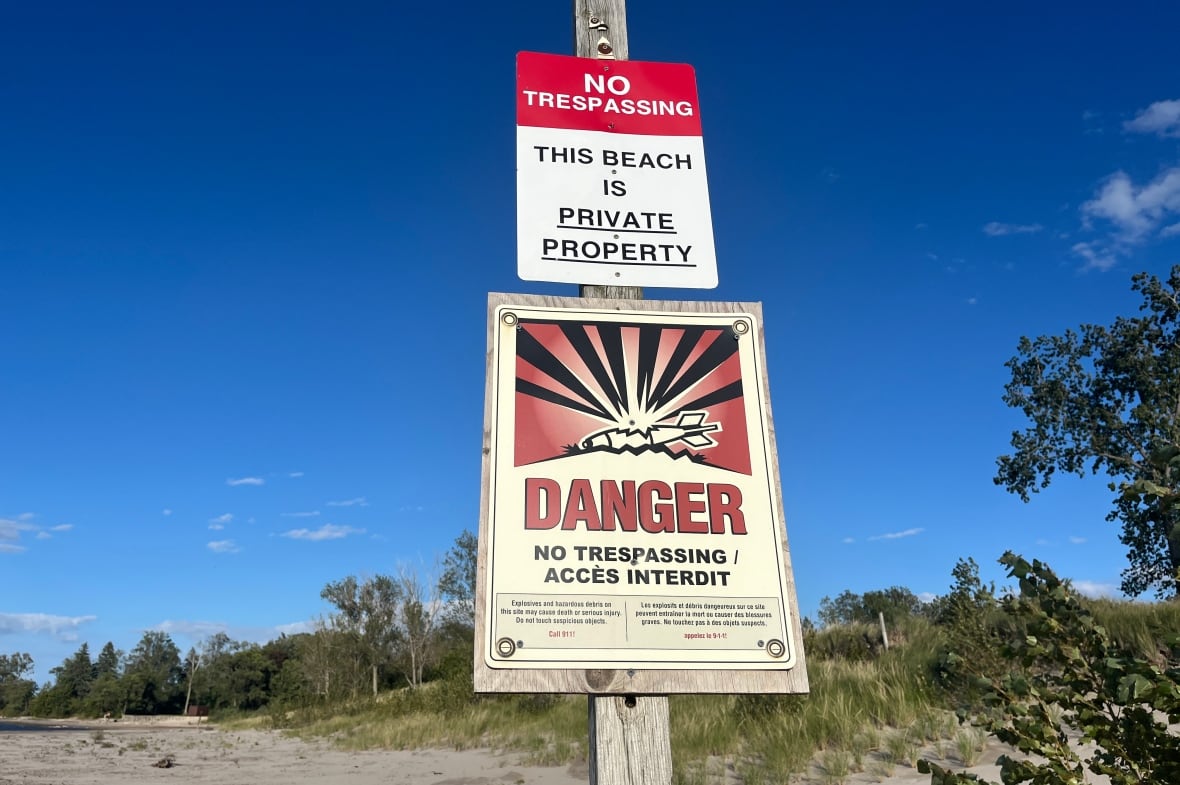Two signs on a wooden post warn against trespassing.
