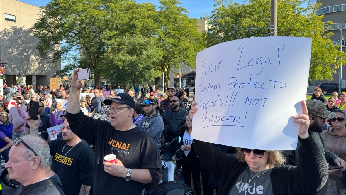 a group of people holds signs 