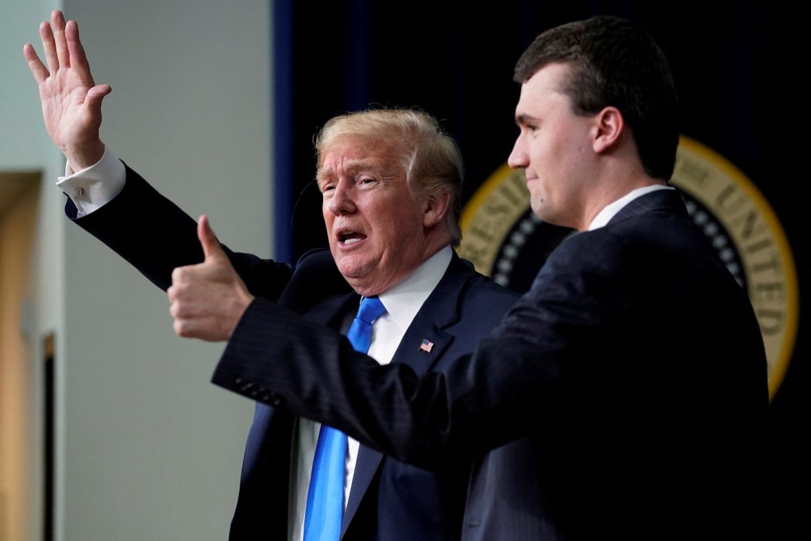Donald Trump and Charlie Kirk standing on a stage in 2018.