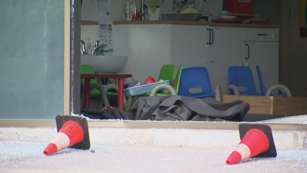 Green and blue chairs are seen through the broken window of the daycare that a vehicle smashed into on Wednesday.
