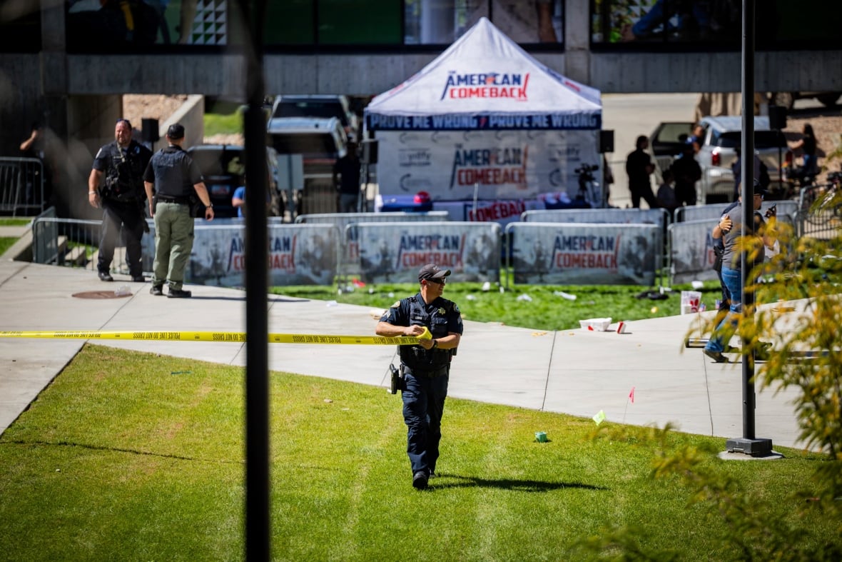 The policeman walks in front of the fried area.