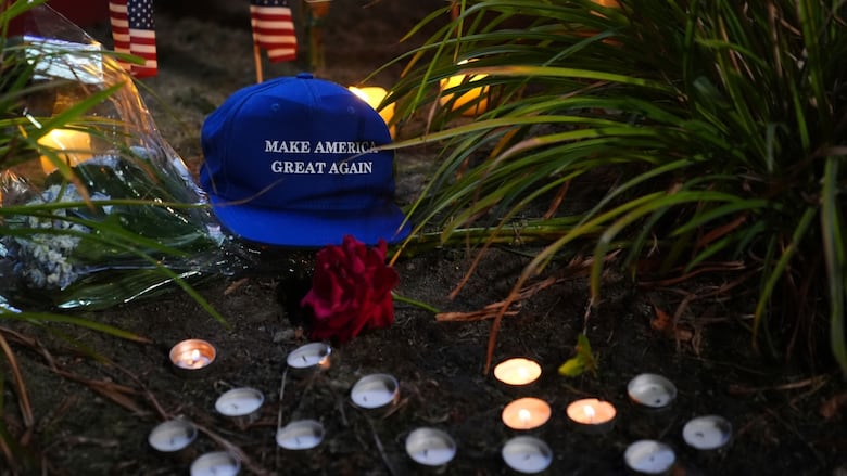 A blue hat labelled 'Make America Great Again' sits beside some candles.