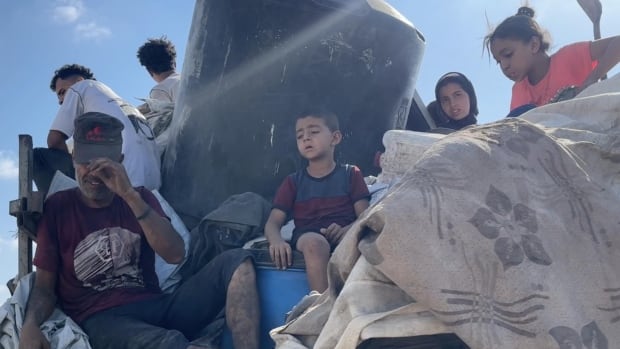 An exhausted family from Gaza City packs up their belongings - including their home's water tank - and heads south,  hoping to find safety from Israeli attacks.
