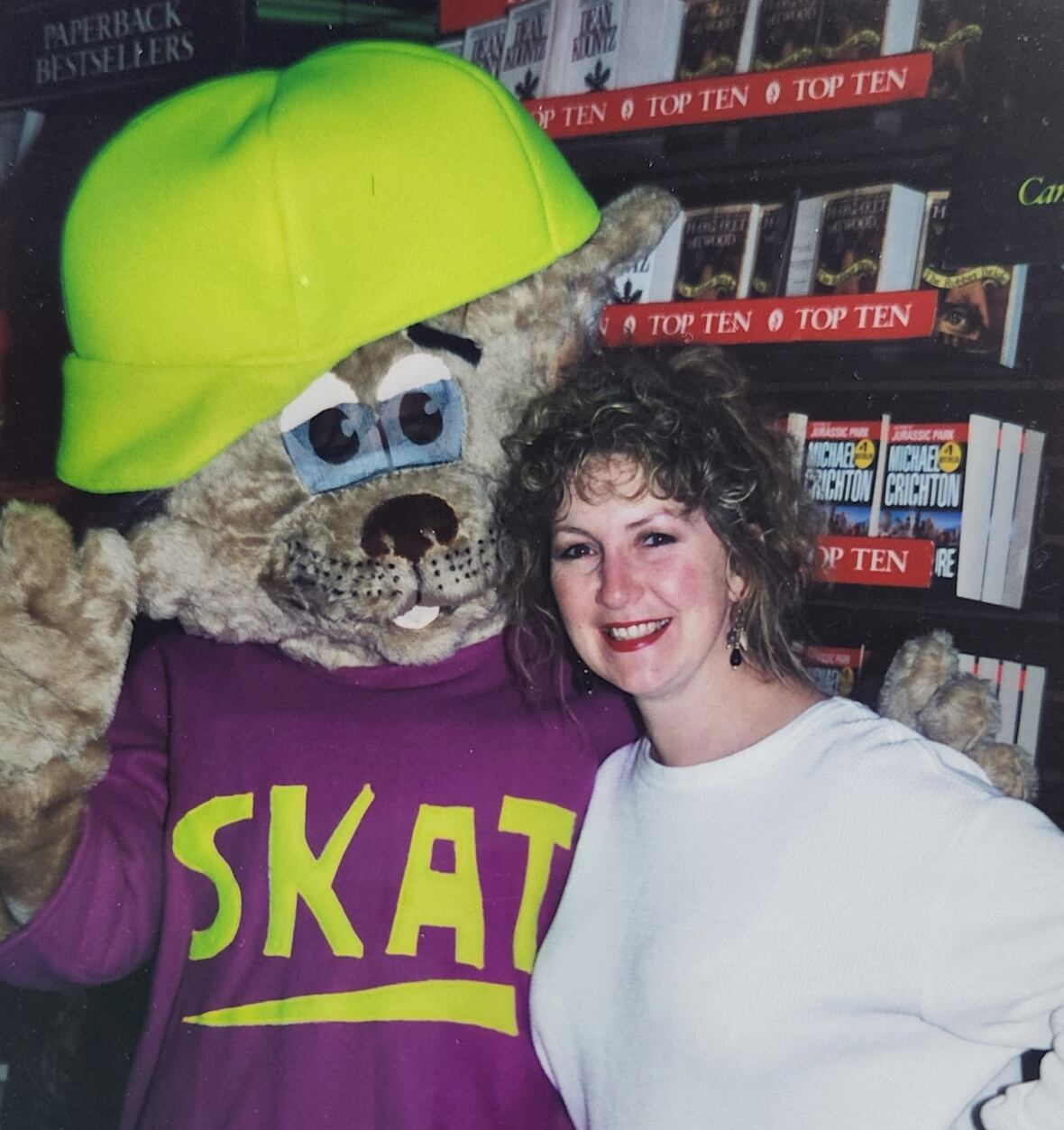 A woman smiles with a cat mascot