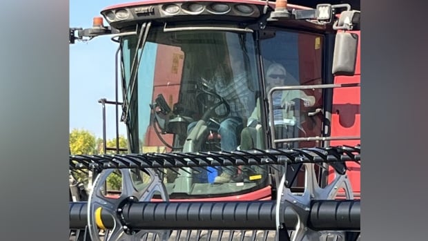 Two people sit in a combine