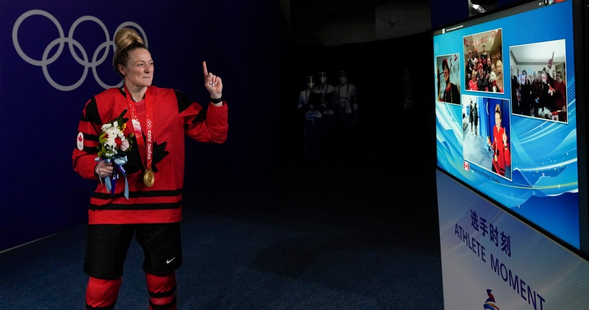 A Team Canada hockey player talks to family through a screen after a game.